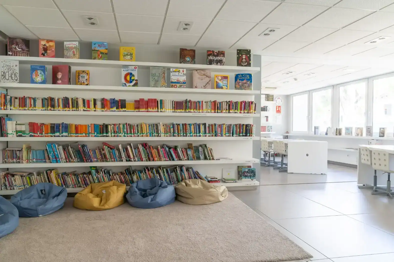 Bright school library interior with colorful books and comfortable seating areas.