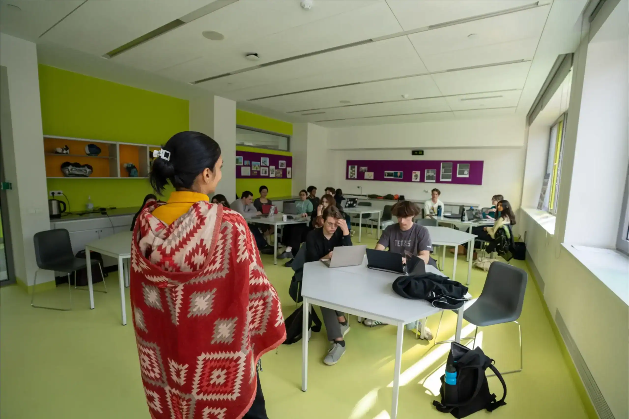 Modern classroom at a world school with diverse students and digital learning tools.