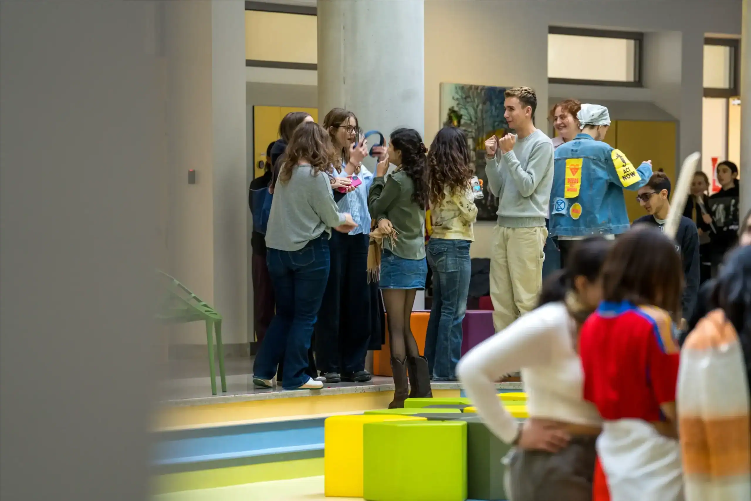Brightly lit indoor scene at World Schools, showcasing diverse students engaging in lively conversations and activities.