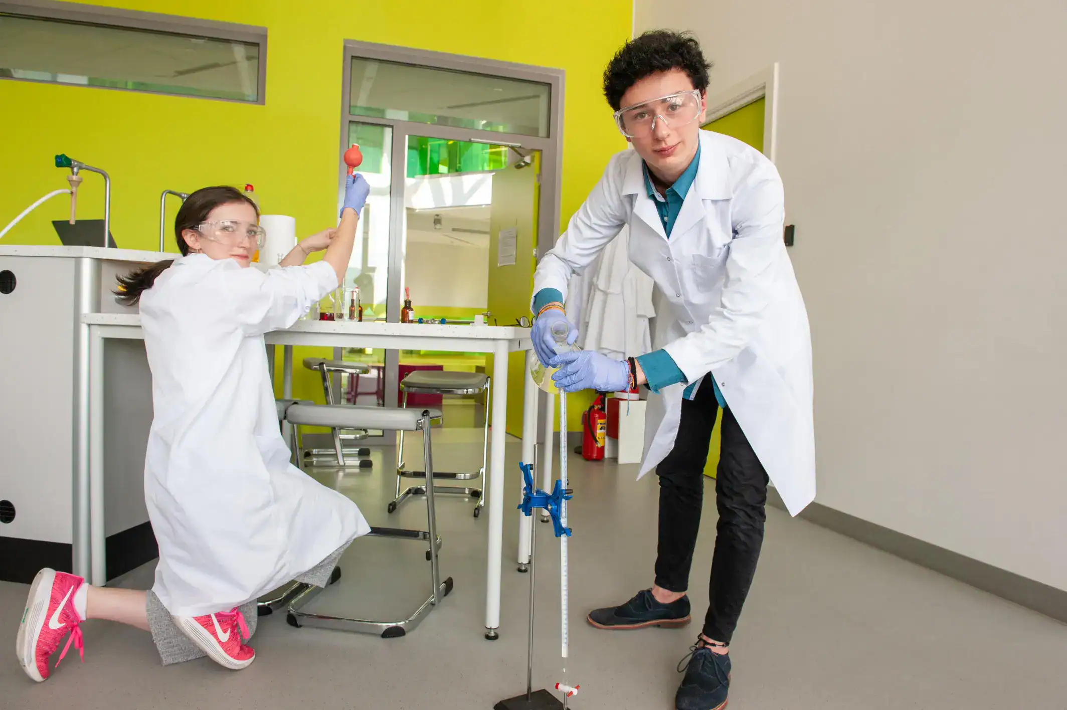 Science students conducting chemistry experiments in a modern school laboratory.