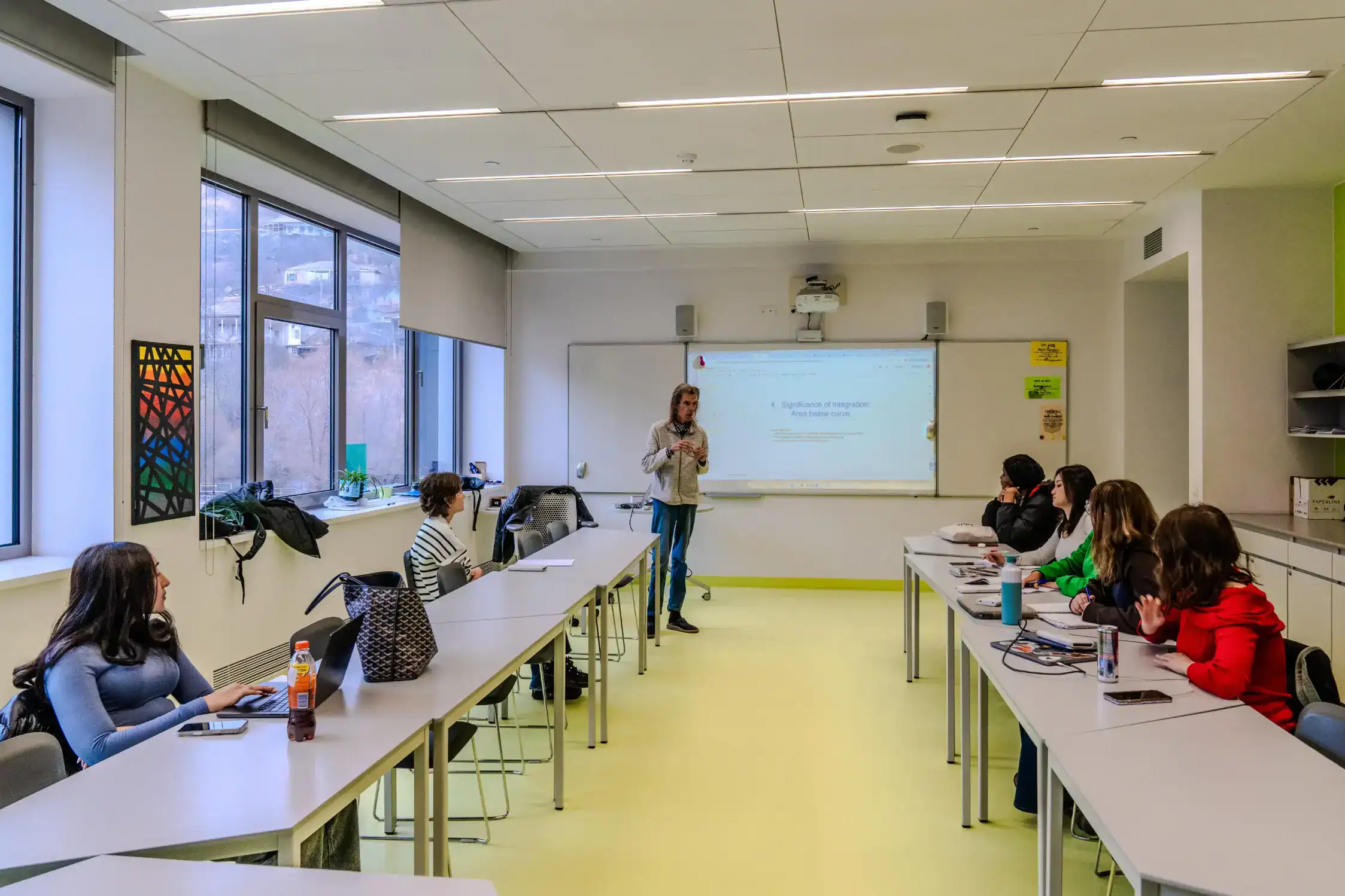 Innovative world schools classroom with diverse students and modern teaching technology.