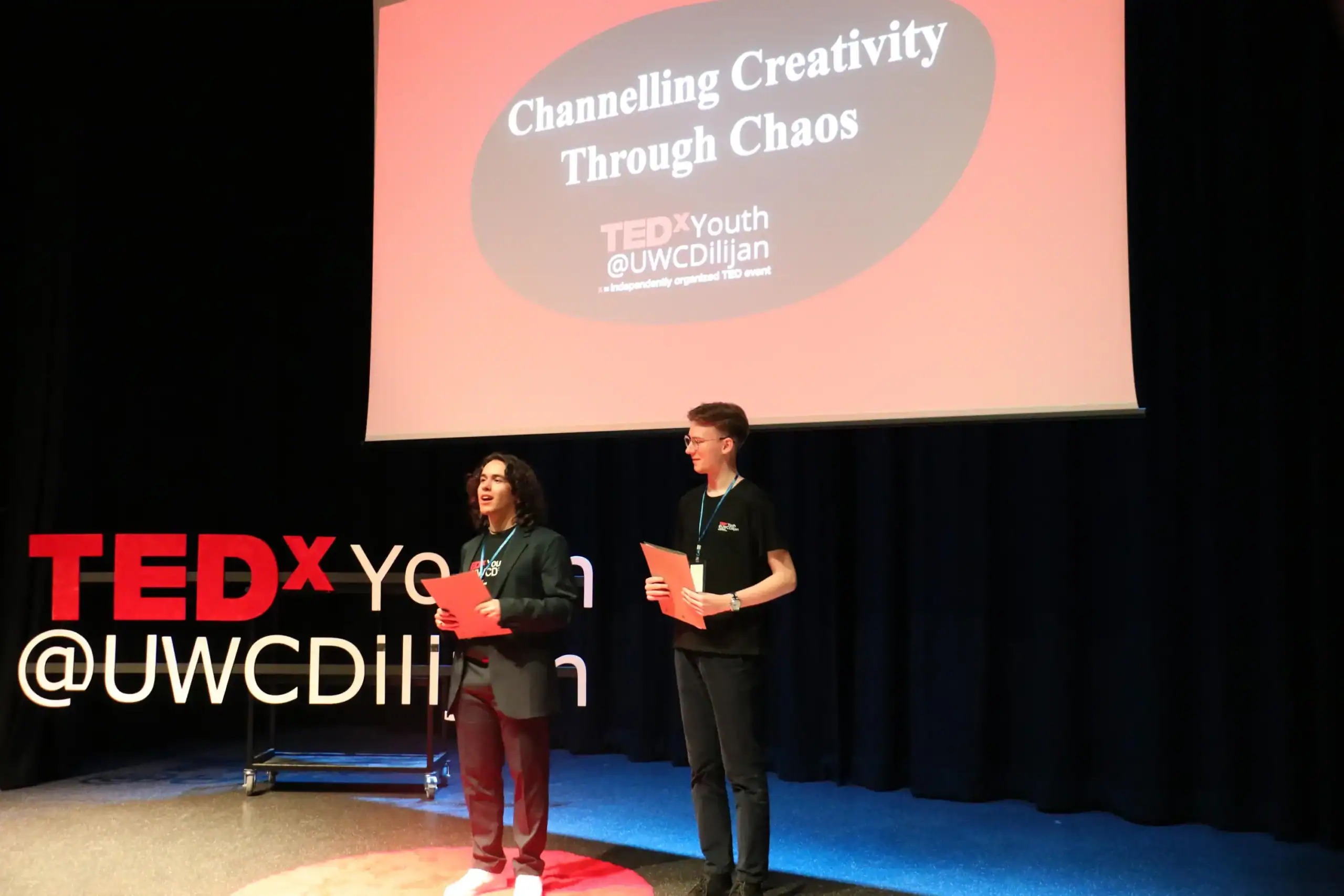 Innovative students presenting at TEDxYouth event focused on creativity through chaos and global education.