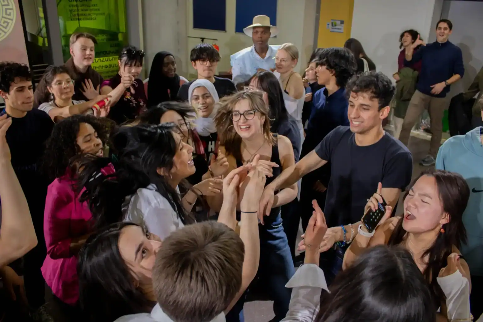 Energetic group of diverse students celebrates together at World Schools, showcasing multicultural unity and vibrant campus life.