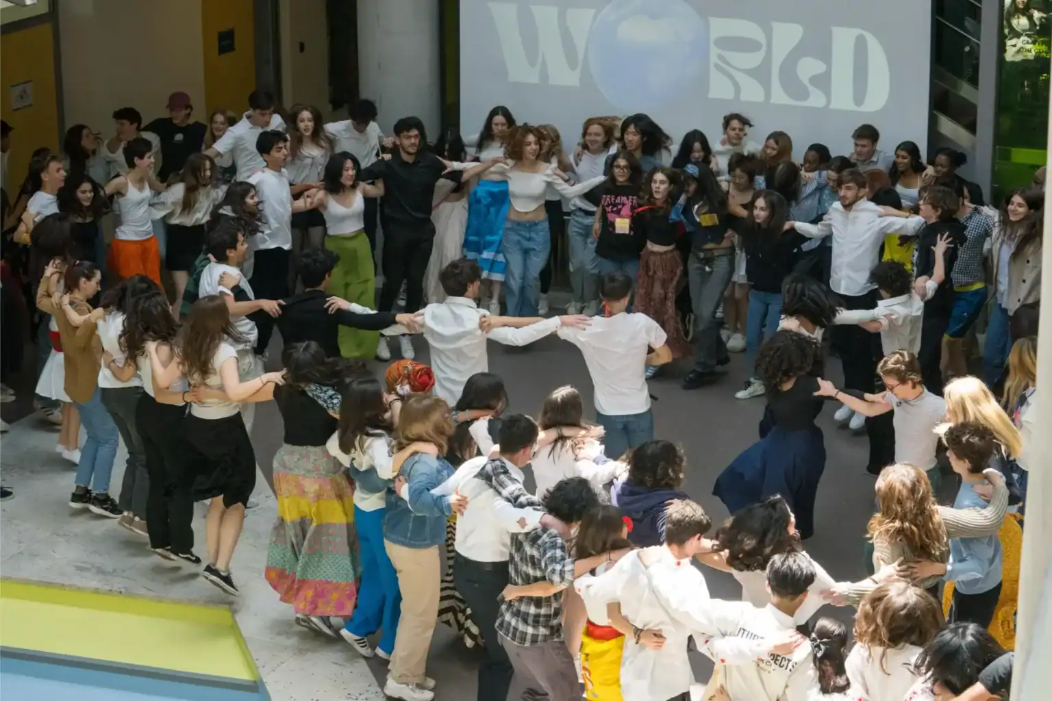 Diverse students participating in a lively outdoor dance at World Schools, showcasing international education and student engagement.