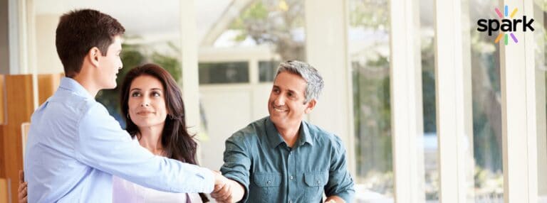 Responsive, diverse students and parents handshake at school admissions, highlighting world schools for global education excellence.