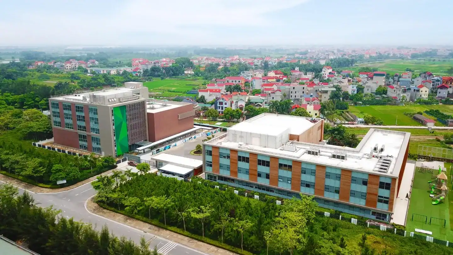 Aerial view of Concordia International School Hanoi campus with modern buildings and green fields.