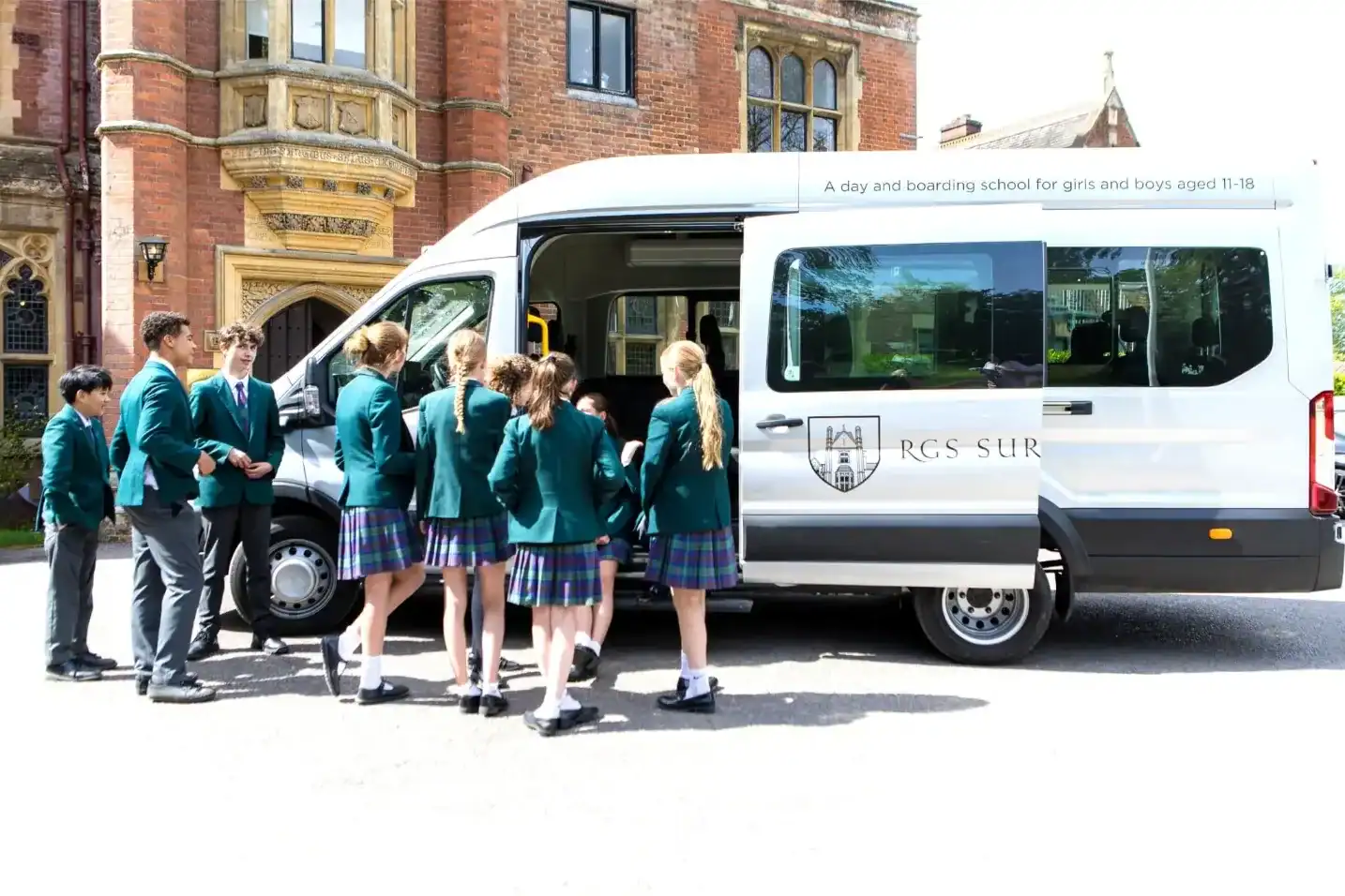 Students boarding a school minibus at RGS Surrey Hills for a school day.