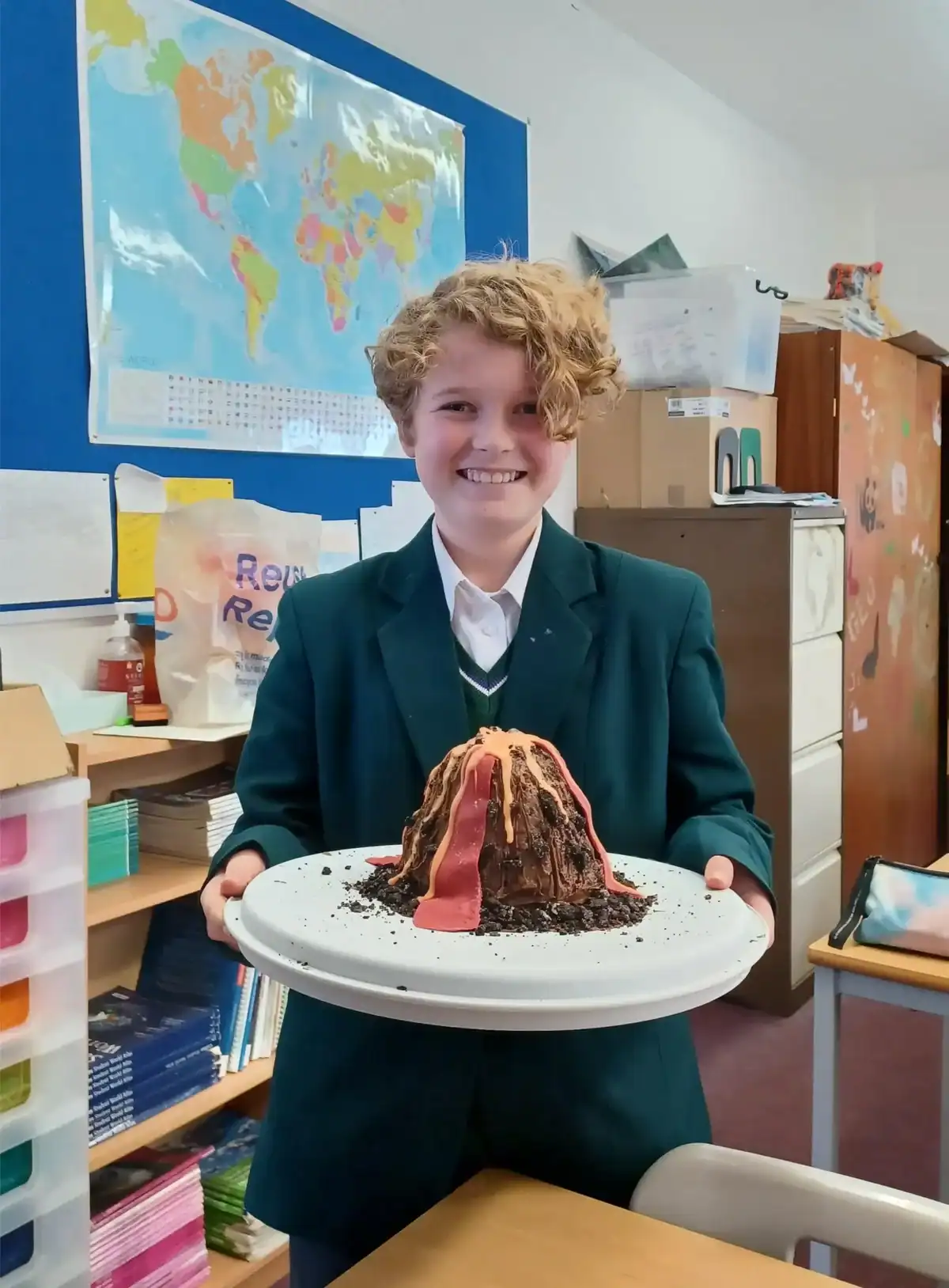 Young student holding a volcano model in classroom at RGS Surrey Hills.