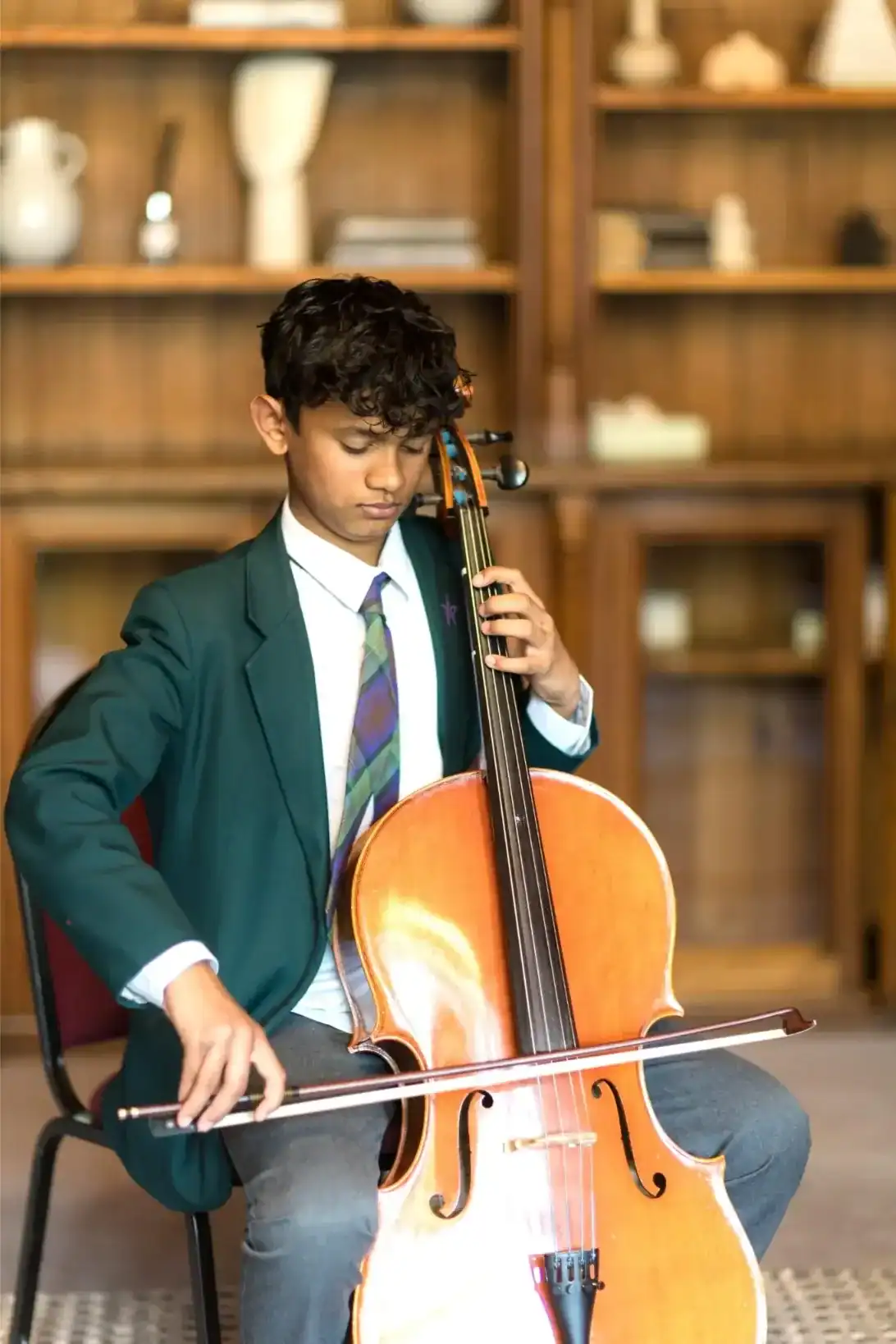 Young student playing cello in a classroom at RGS Surrey Hills.