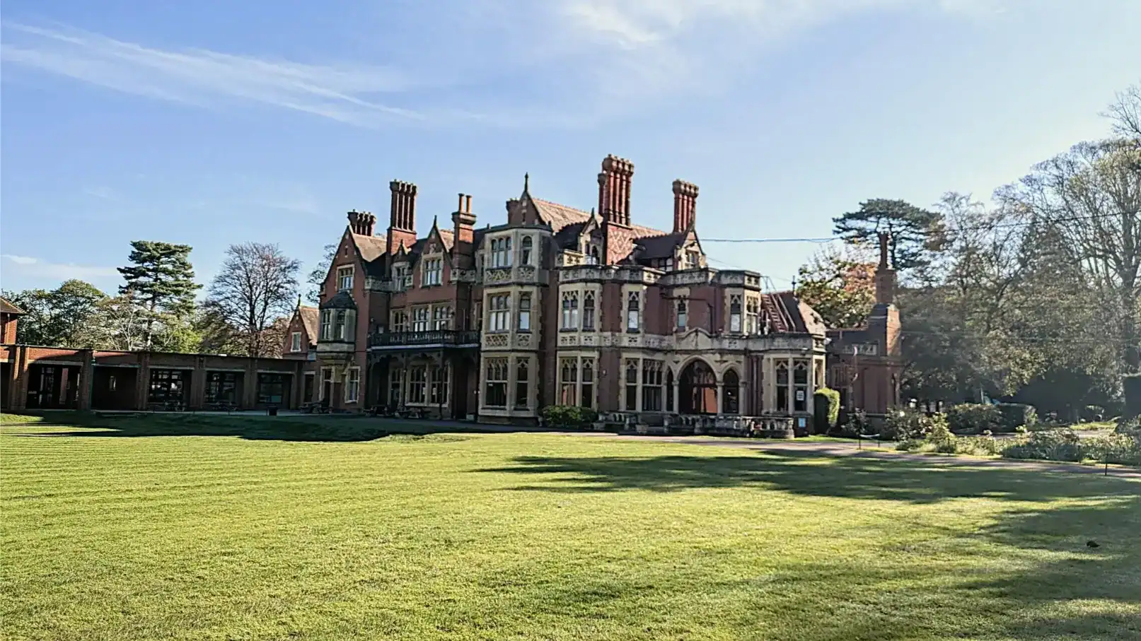 Historic mansion at RGS Surrey Hills with lush green grounds and blue sky.
