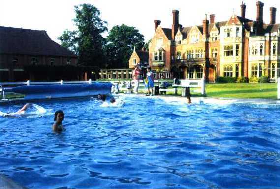 Children swimming in an outdoor pool at RGS Surrey Hills school.