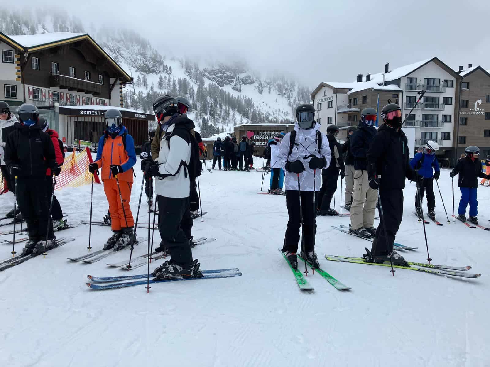 Skiers gathered at a snowy ski resort in the mountains.