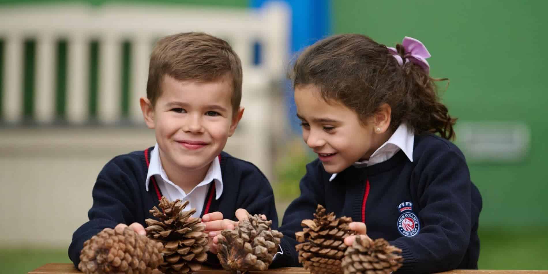 1. Two diverse schoolchildren enjoying outdoor activities with pinecones at school.