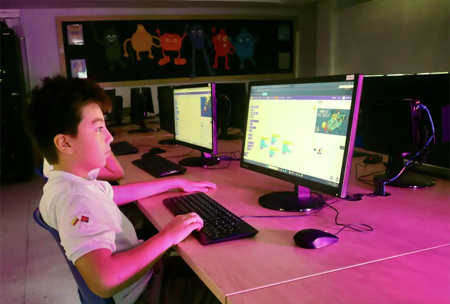 Bir dünya okulunda kodlama ve dijital öğrenme odaklı modern bir sınıfta bilgisayarlarda çocuk programlama.