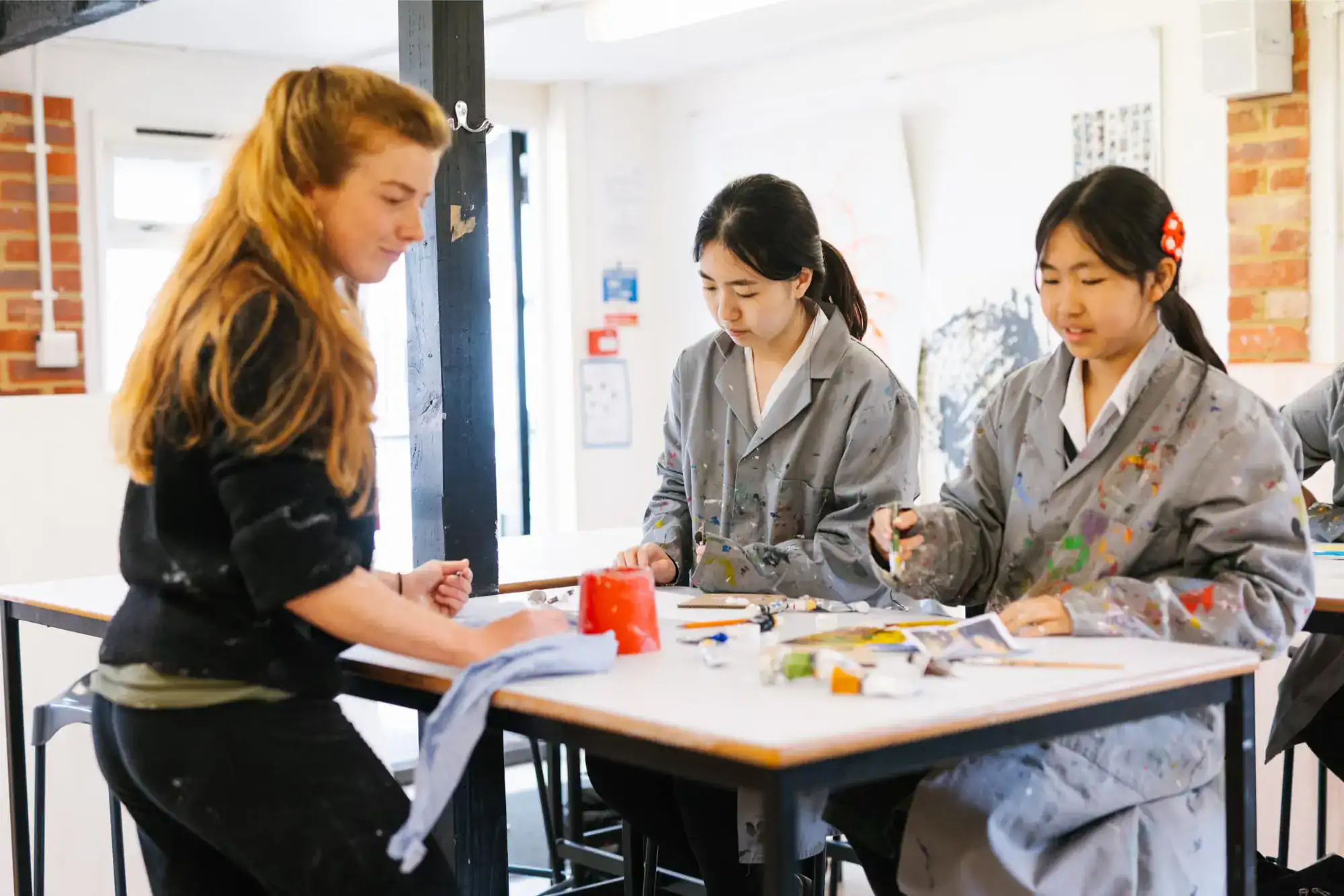 Creative school art class with students and teacher in modern art studio, fostering creativity and learning.