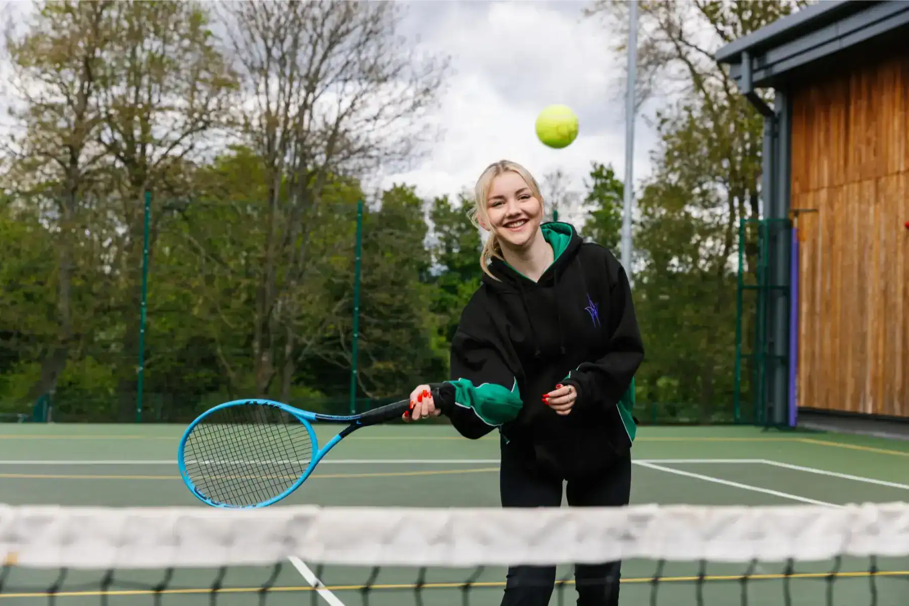 Active student playing tennis at a school sports court for optimal learning and fitness.