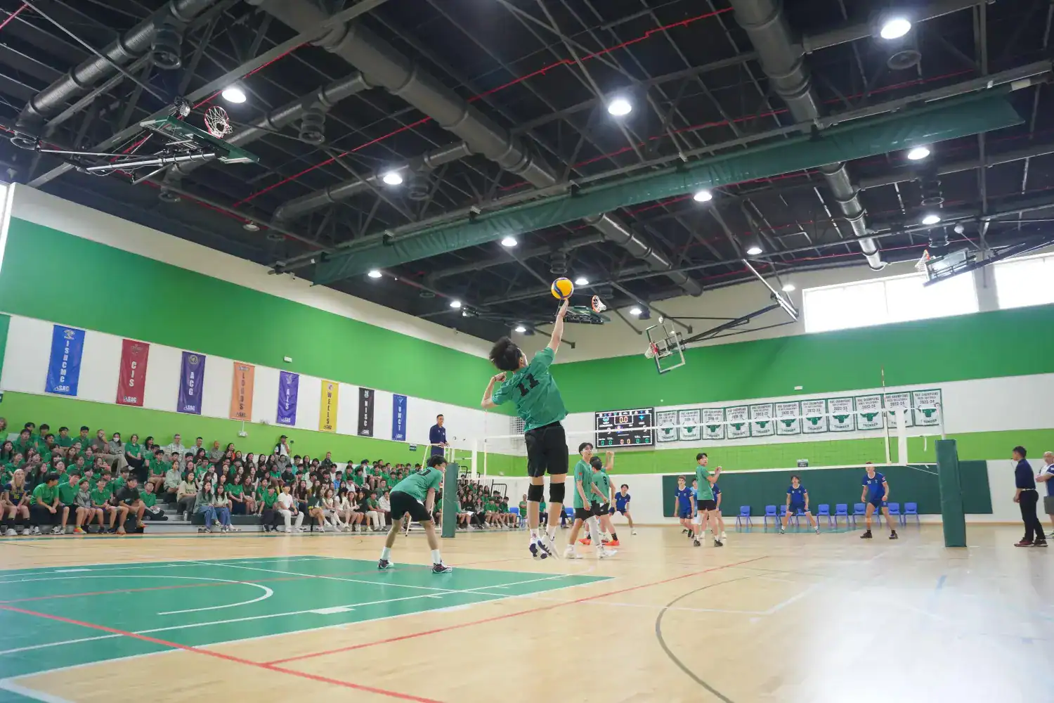 Youth volleyball game in a school gymnasium for World Schools education.