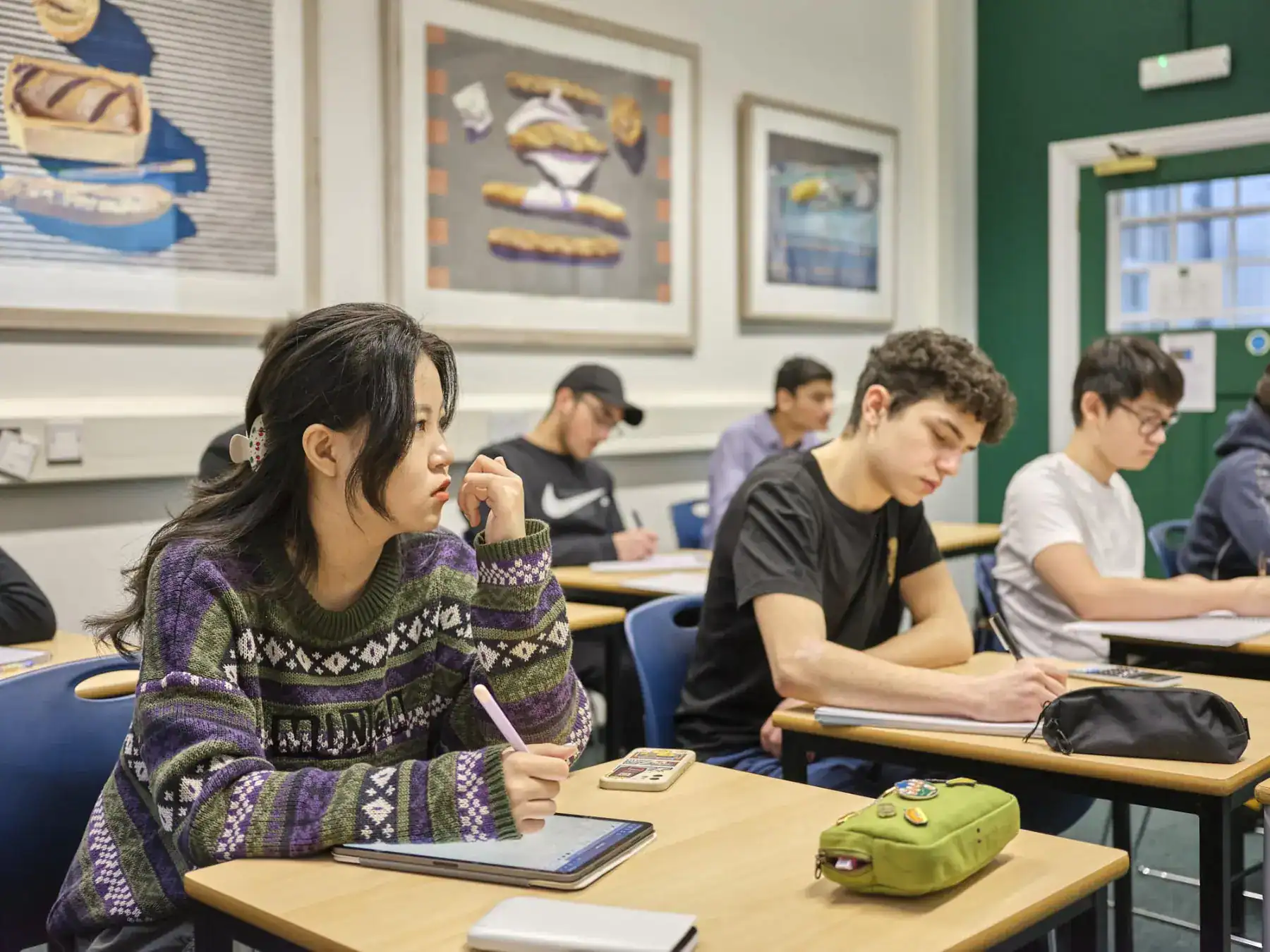 Focused students attentively learning in a diverse classroom setting at World Schools.