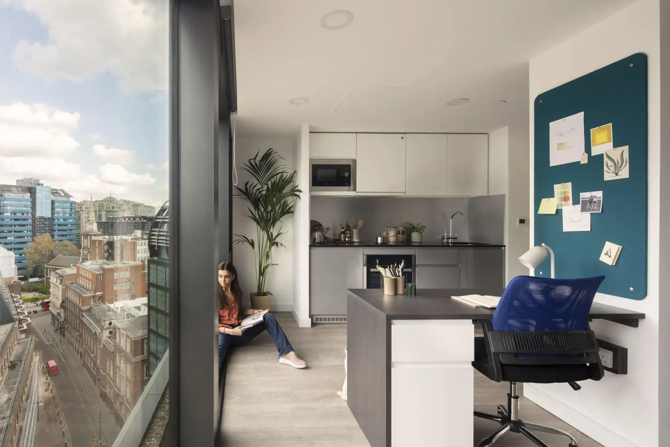 Bright modern home office with city view, bookshelf, and workspace for remote learning and studying.