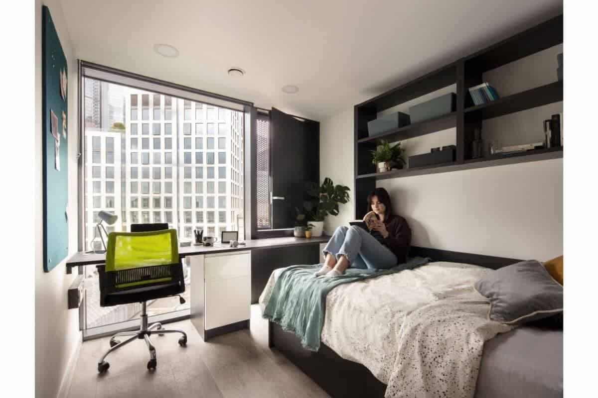 Modern student dorm room in a top international school, featuring study desk, bookshelf, and cozy bed, ideal for student life and learning.