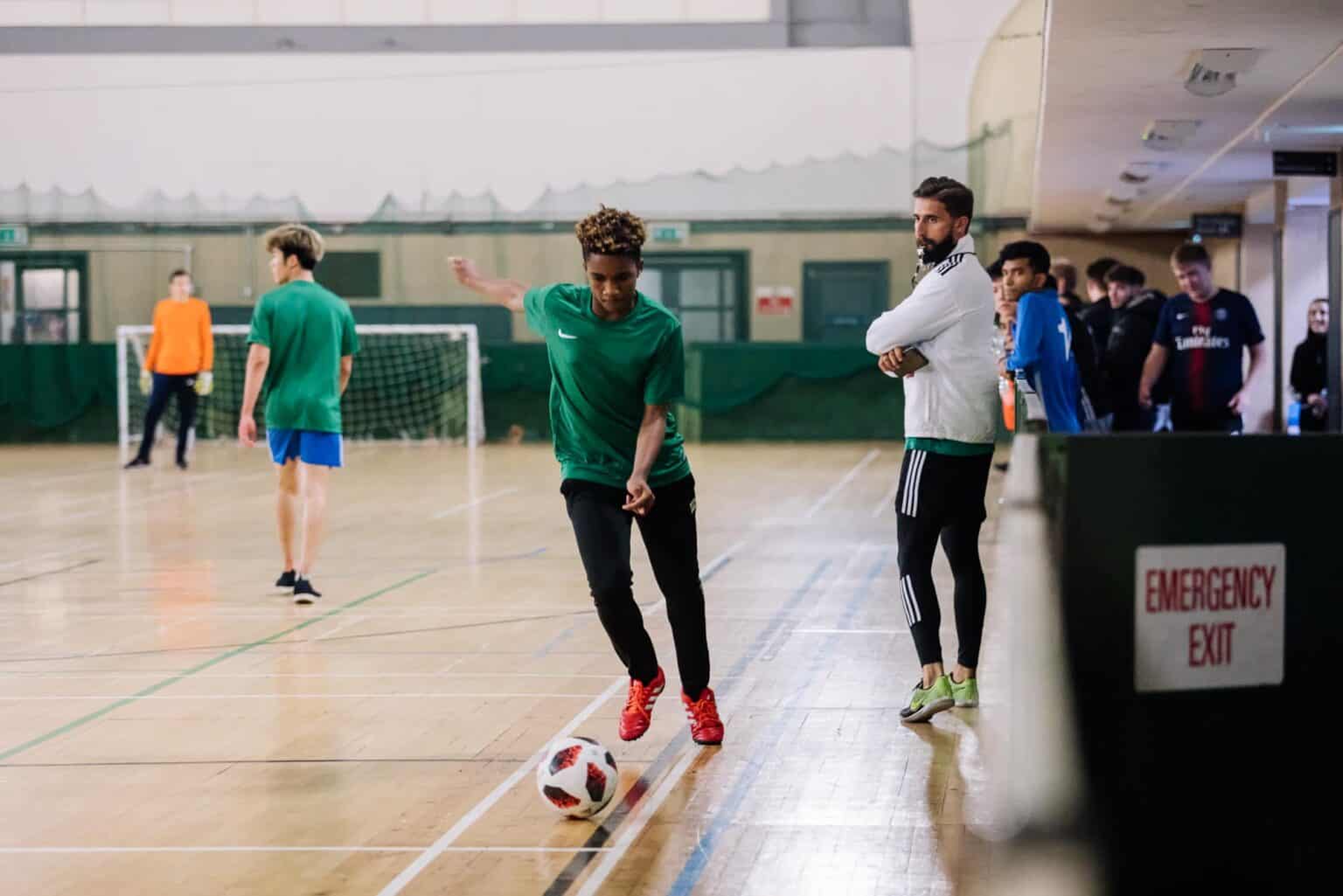 Young soccer player practicing indoor soccer at a World Schools sports event.