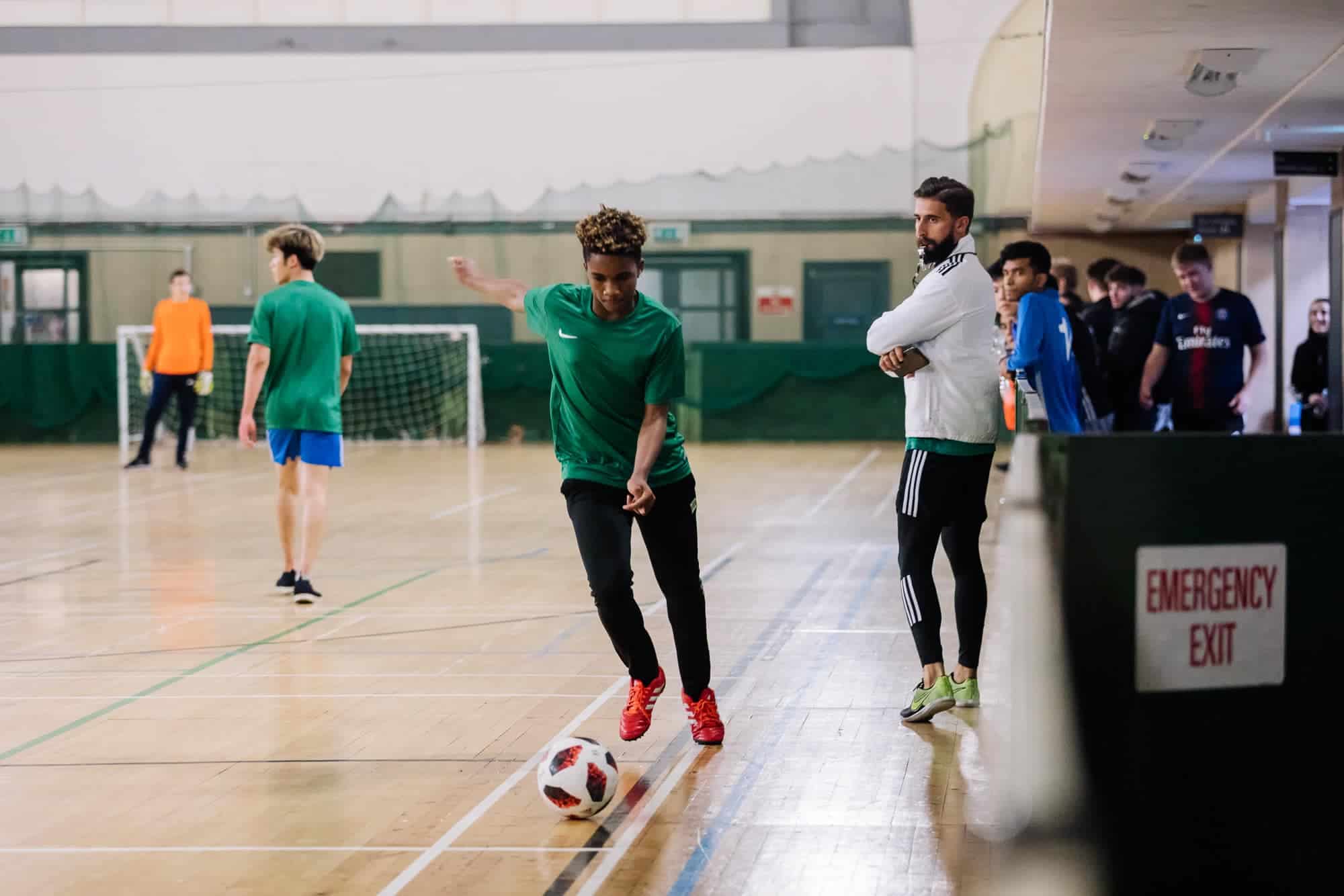 Young soccer player practicing indoor soccer at a World Schools sports event.