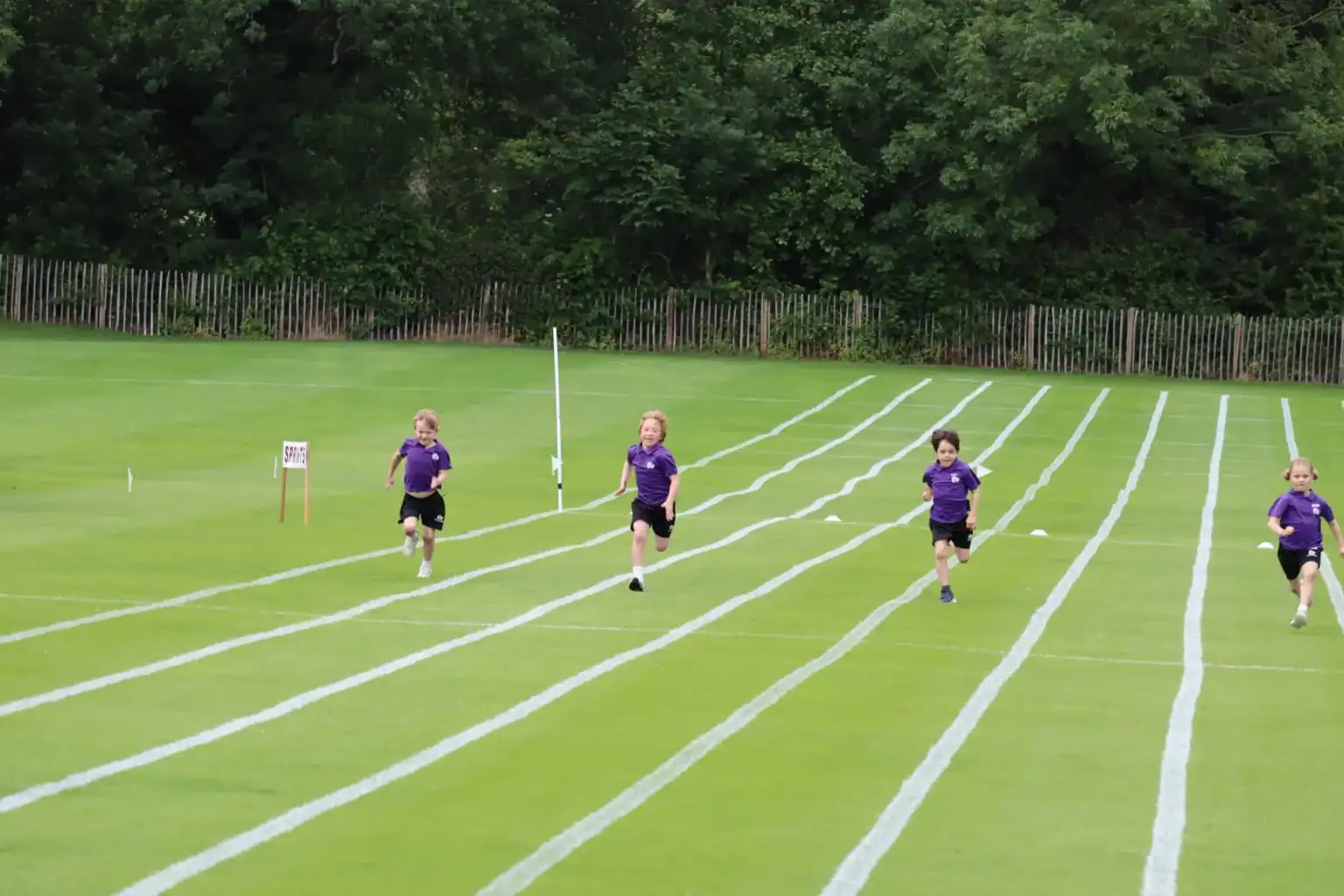 Children running on a sports track at a school athletics event, outdoor sports, active kids, physical education.