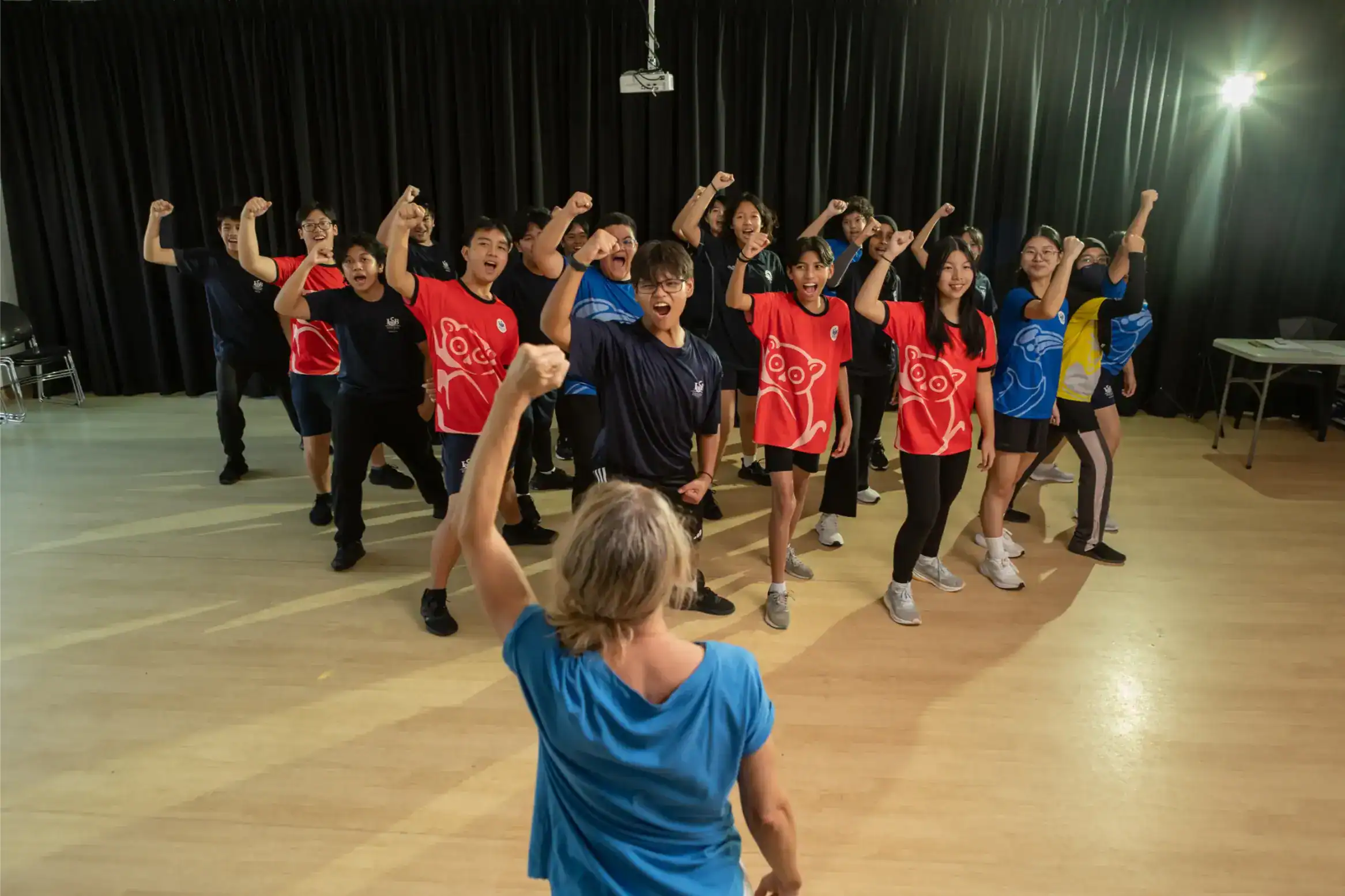 Vibrant group of students engaged in a dynamic team-building activity at a World Schools event.