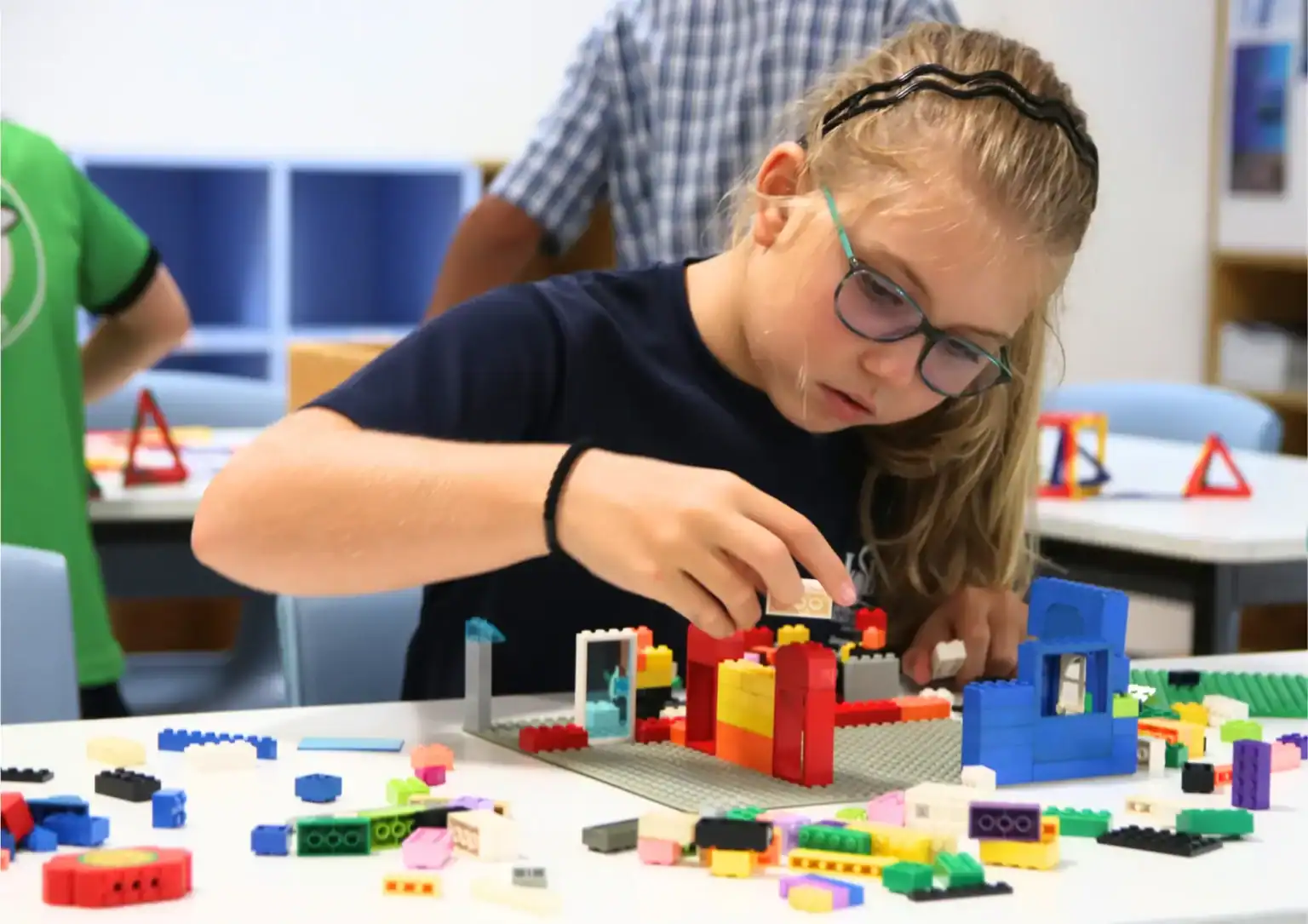 Creative student building with LEGO bricks at an international school, fostering innovation and STEM skills.