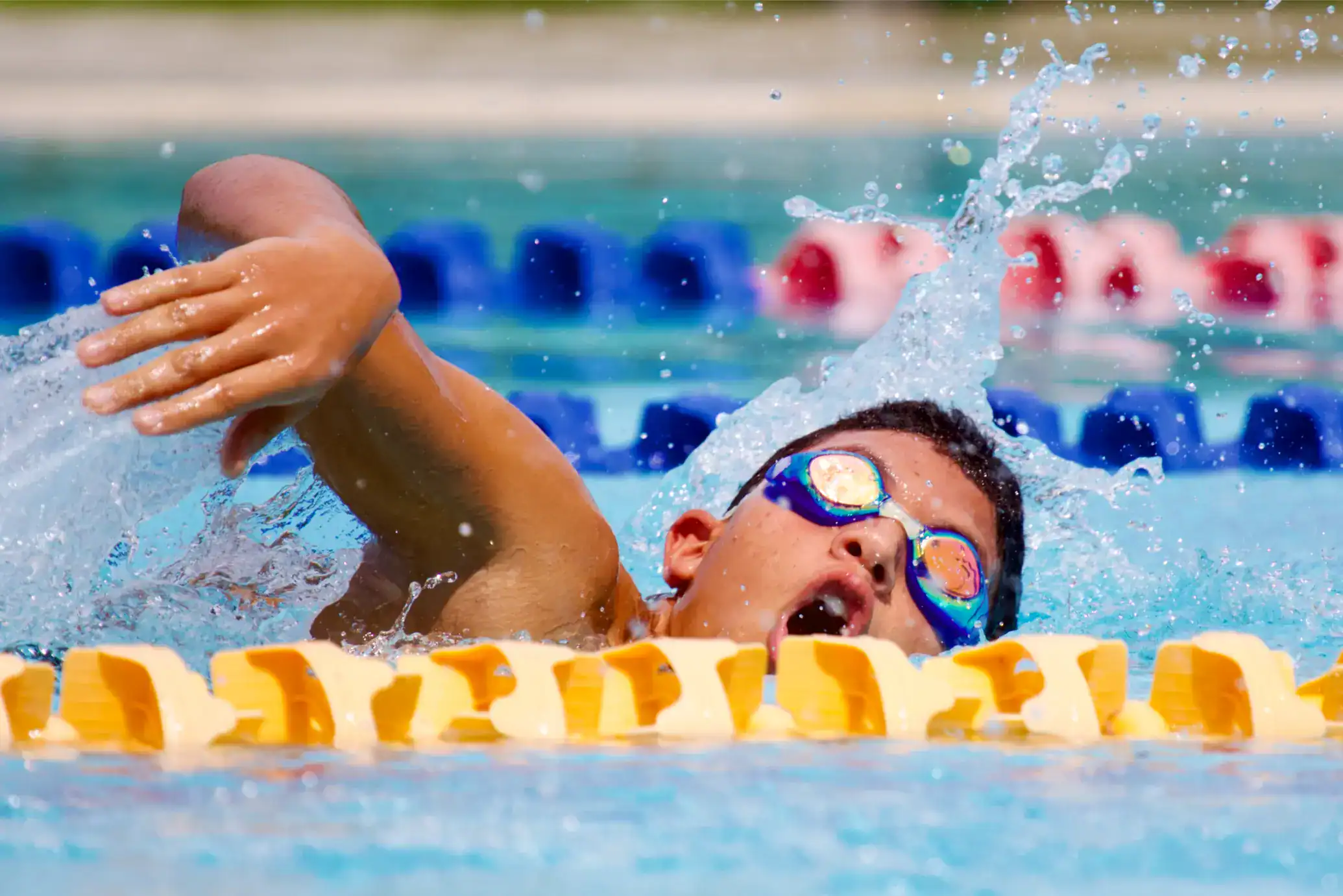 Energetic child swimming in a race at World Schools swimming competition.