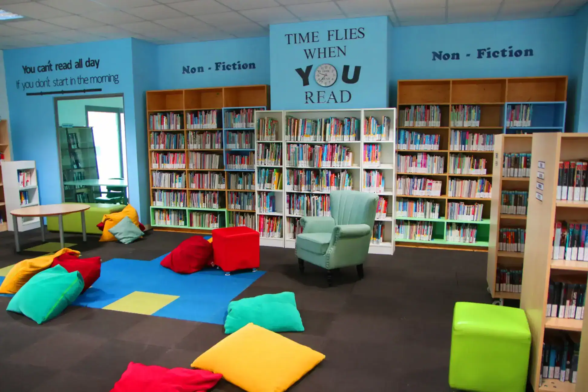 Inspirational school library with colorful bean bags and extensive book collections for student learning.