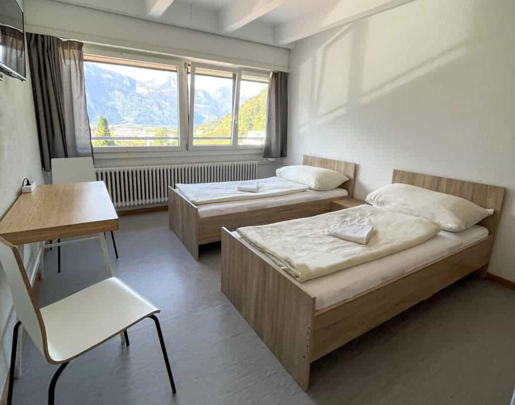 Modern twin bedroom with mountain view in a World Schools student accommodation.