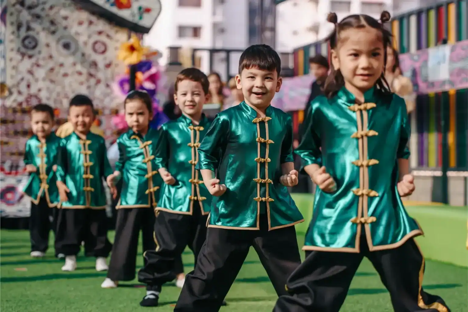 Brillantes niños con trajes tradicionales chinos participan en un desfile cultural en un acto de los Colegios del Mundo.