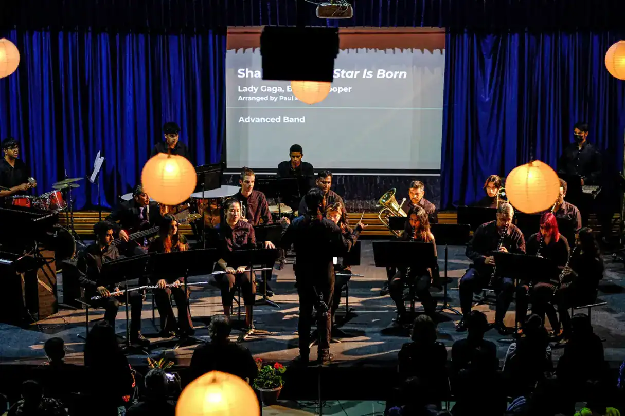 明亮的学校乐队在现场音乐会上表演，蓝色的幕布和灯笼，展示了世界学校学生的才华。.