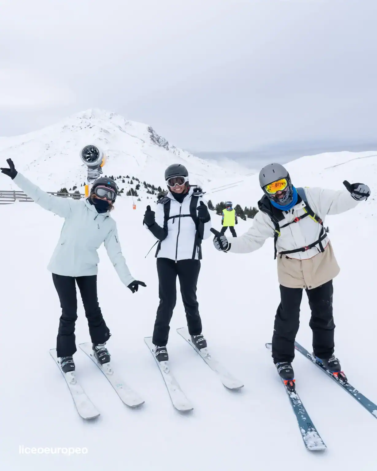 Happy skiers enjoying winter sports on snowy mountain at world schools ski trip.