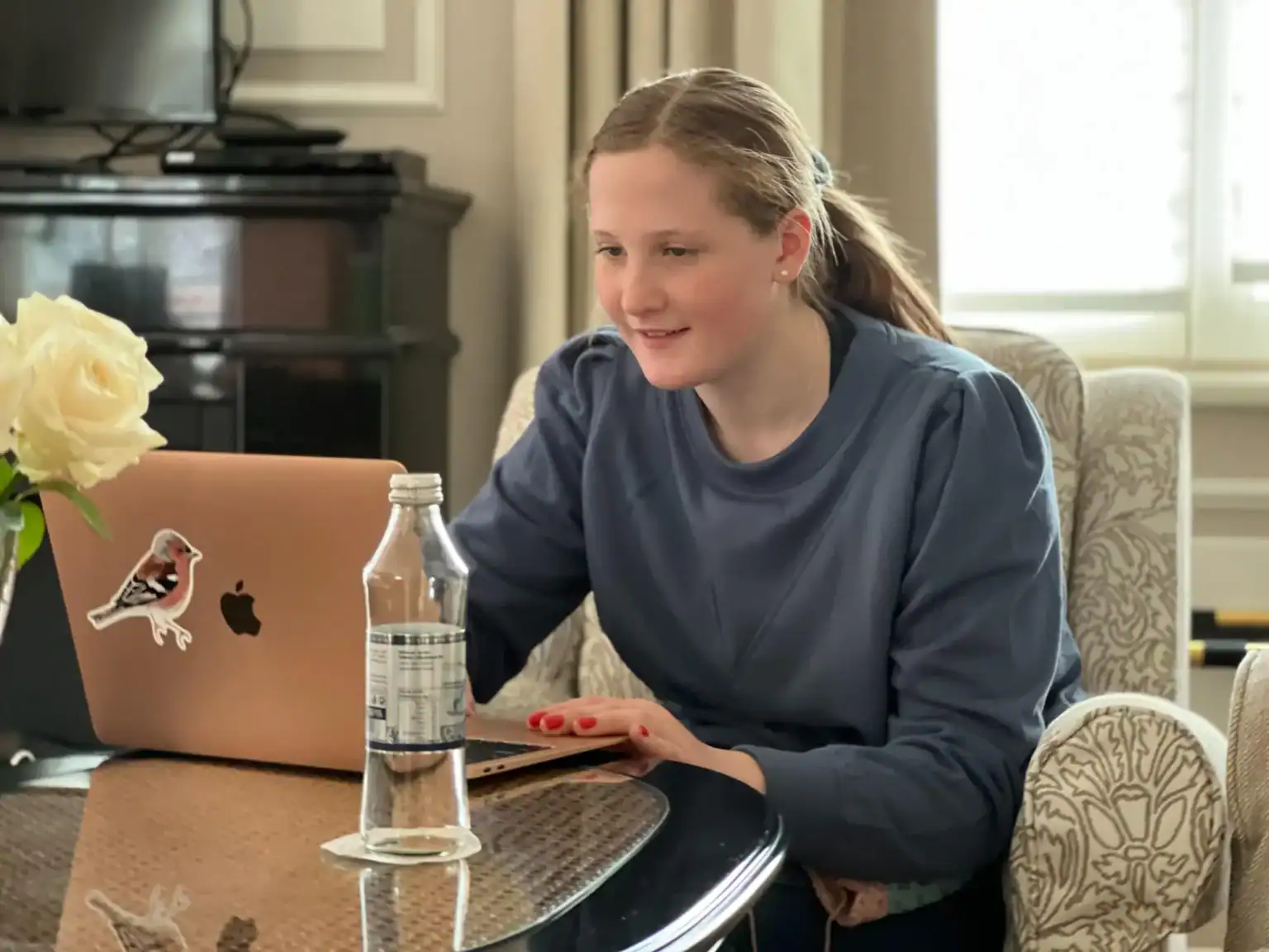 Young girl studying on a laptop at home, representing online learning and global education.