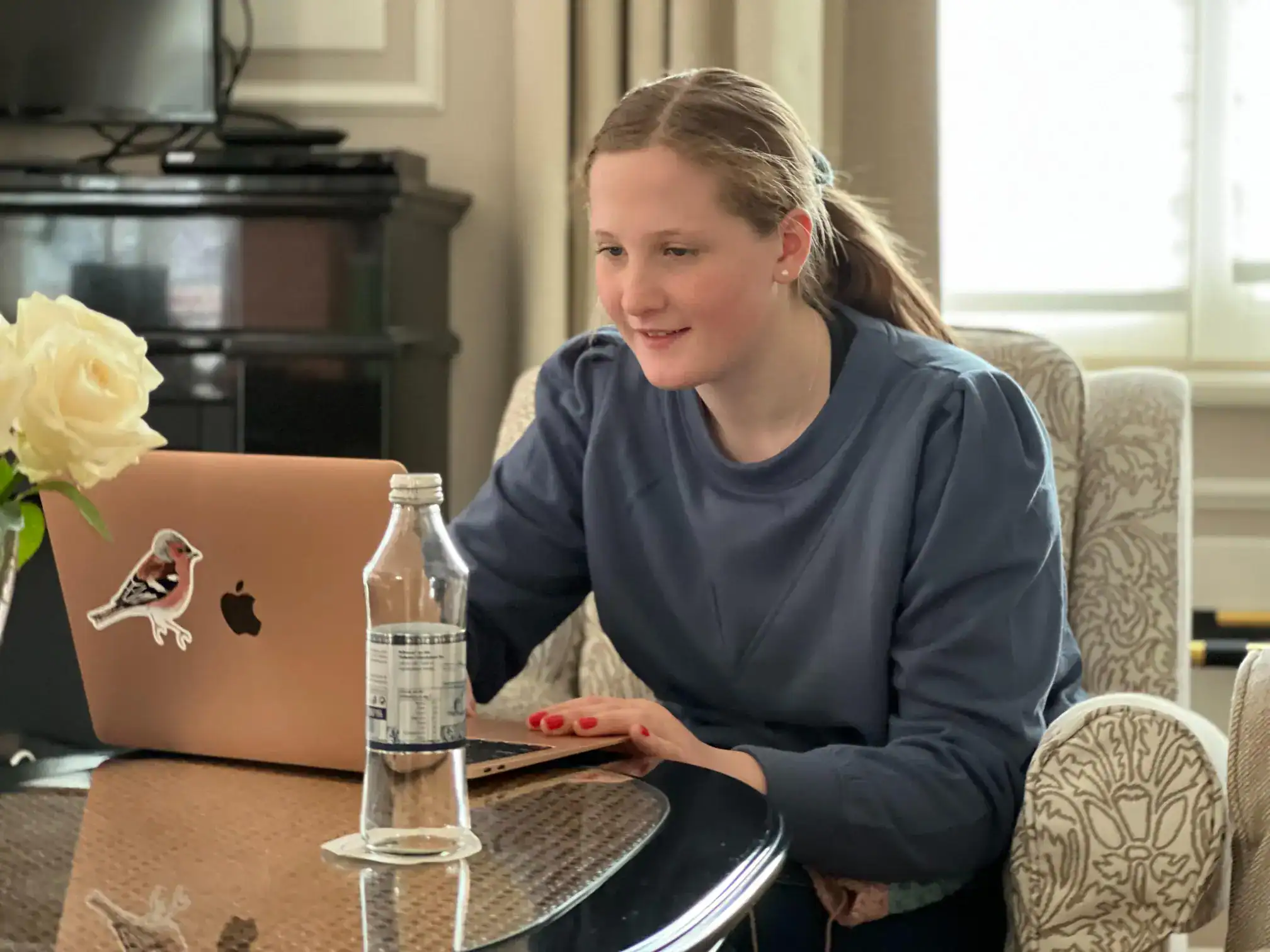 Young girl studying on a laptop at home, representing online learning and global education.