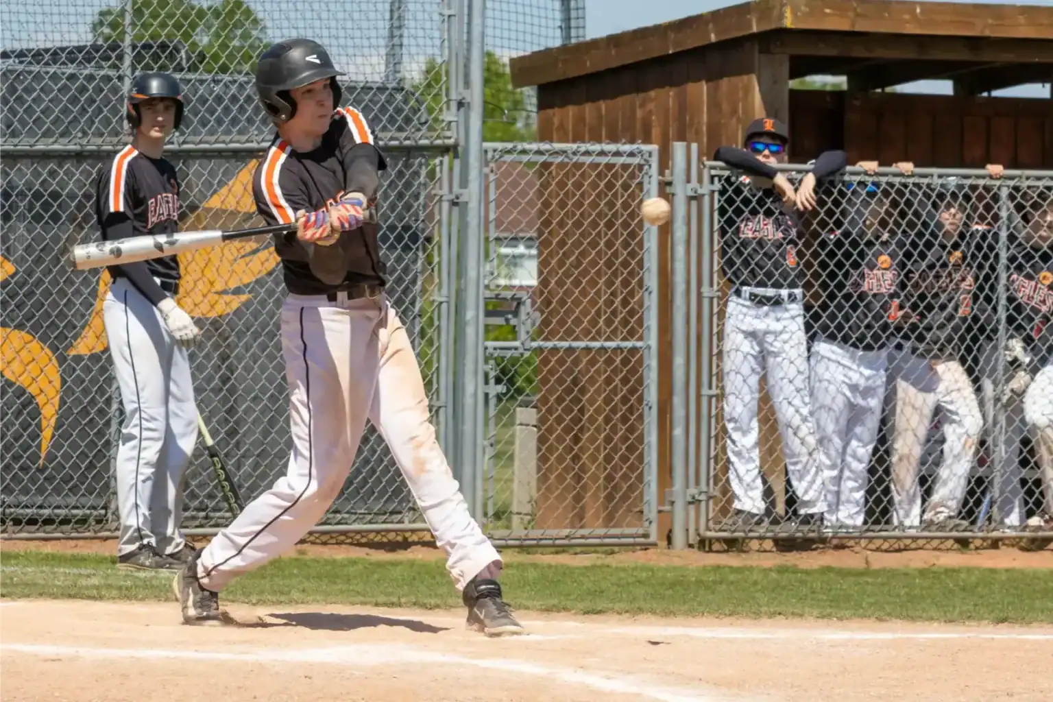 Youth baseball game at a school sports field with players in action.