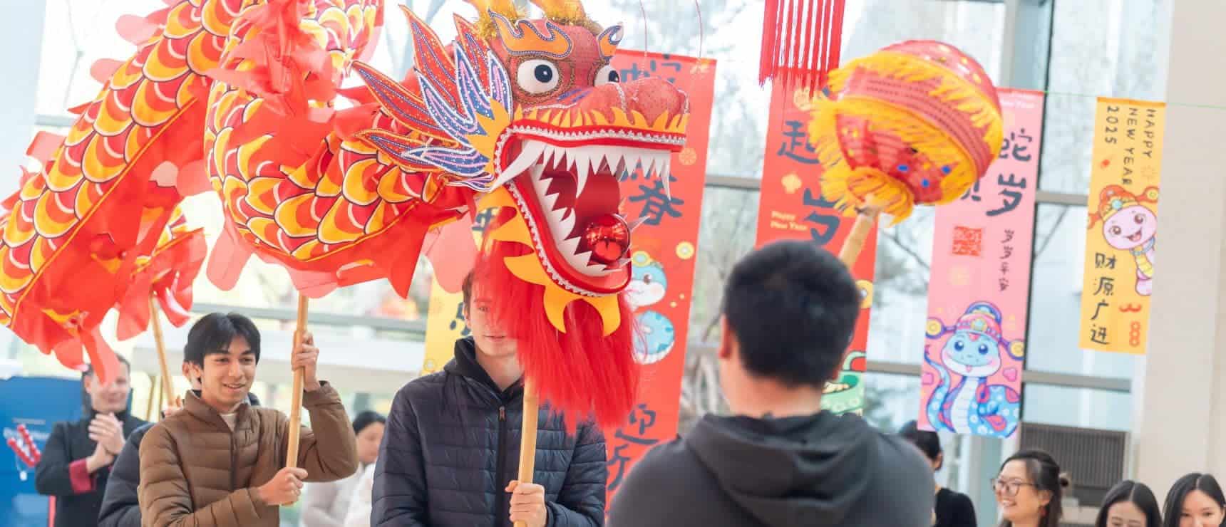 Colorful Chinese New Year celebration with dragon dance and traditional decorations at World Schools event.