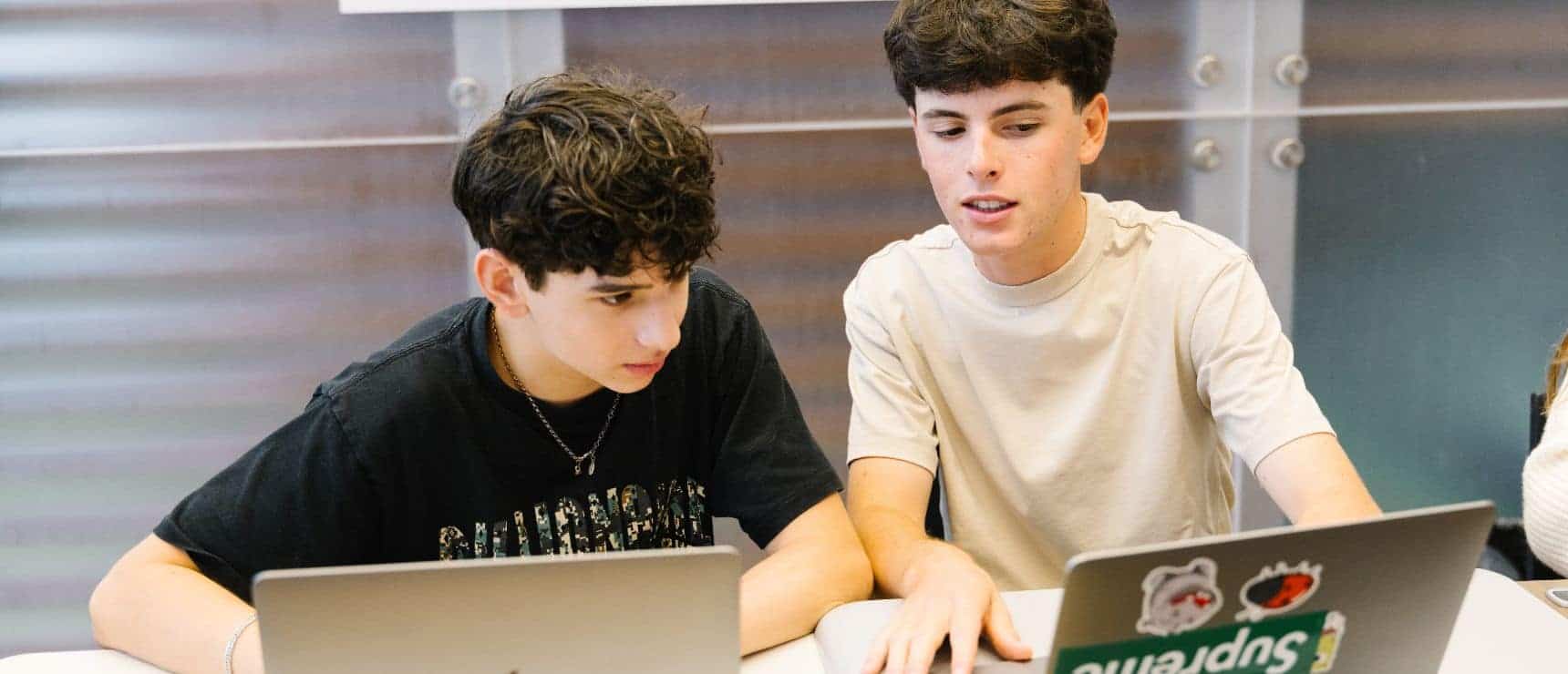 Focused students collaborating on laptops in a diverse educational environment at World Schools.