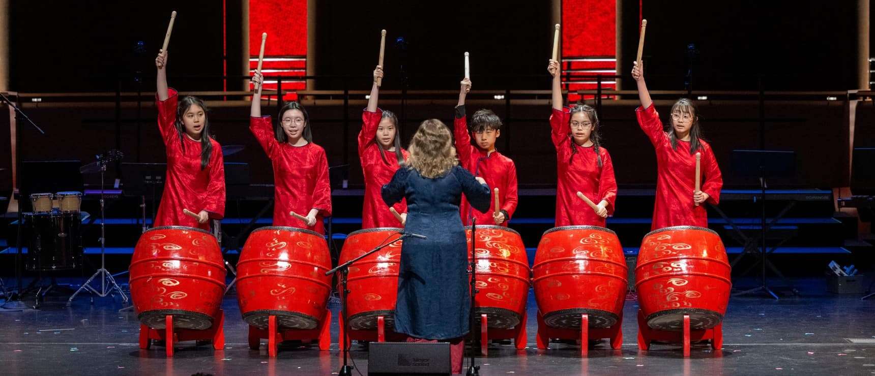 Children performing traditional Chinese drumming on stage at World Schools event.