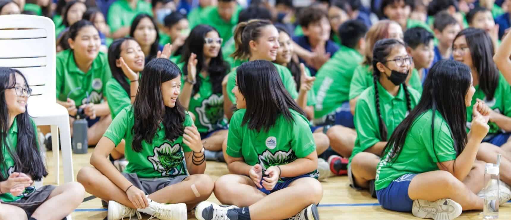 Students in green uniforms enjoying a school event at World Schools.