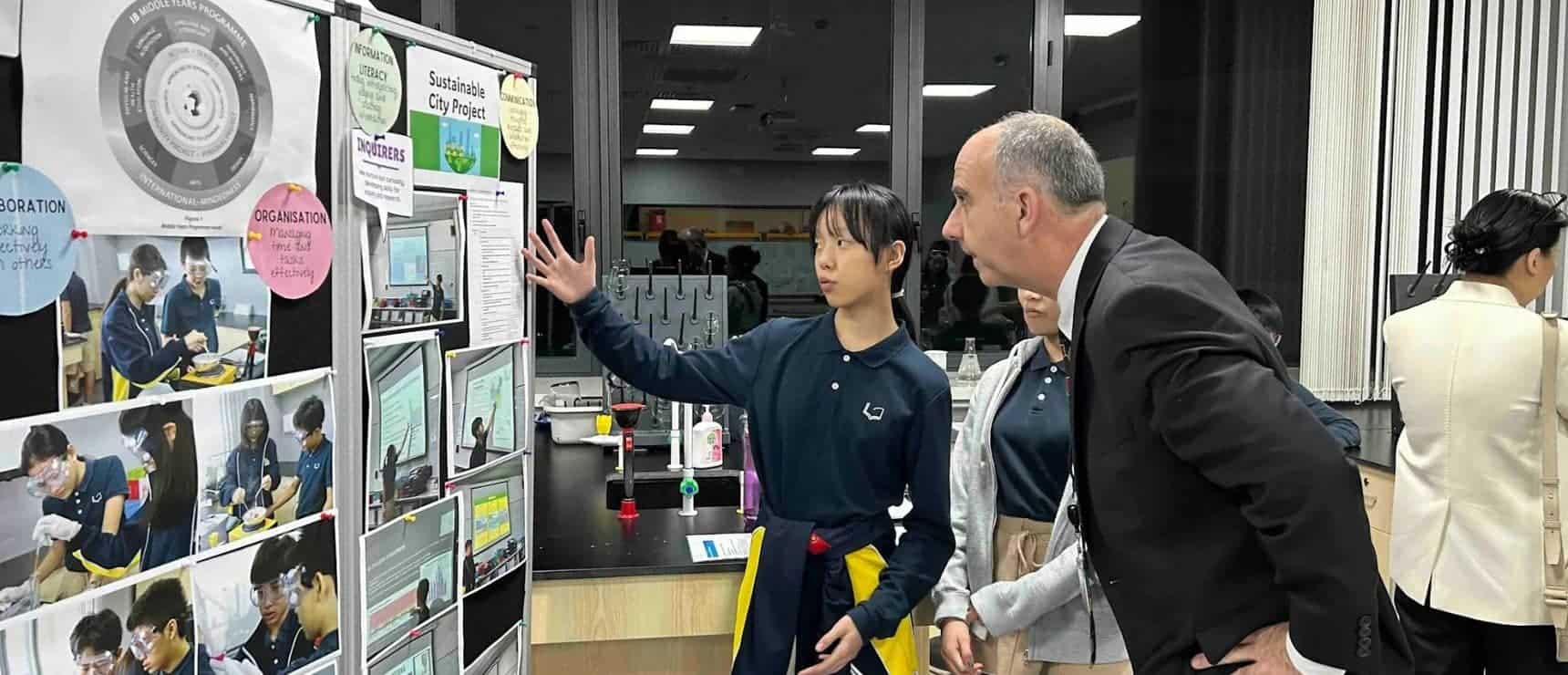 Innovative student presentation at World Schools science fair, showcasing project on sustainable city development.