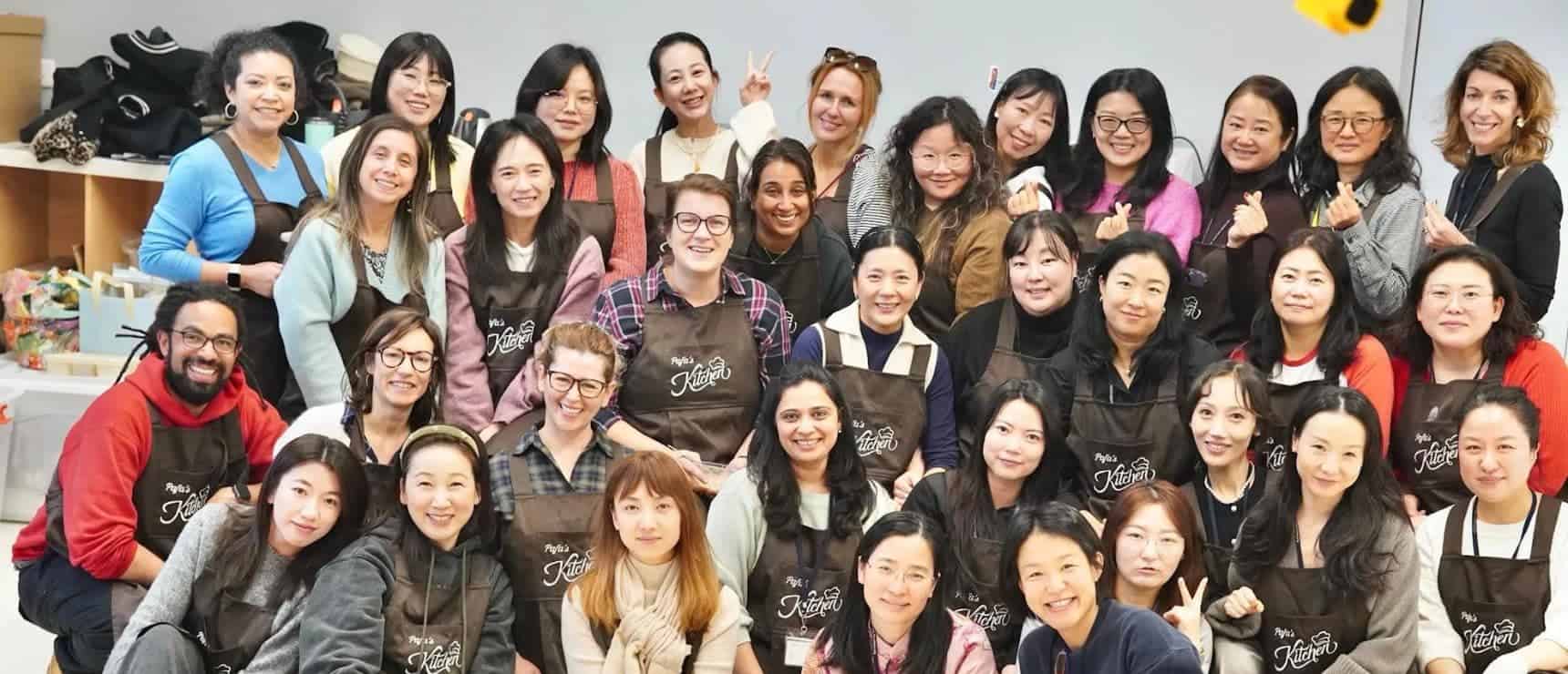 Diverse group of women participating in a cooking class, highlighting community and educational opportunities at World Schools.