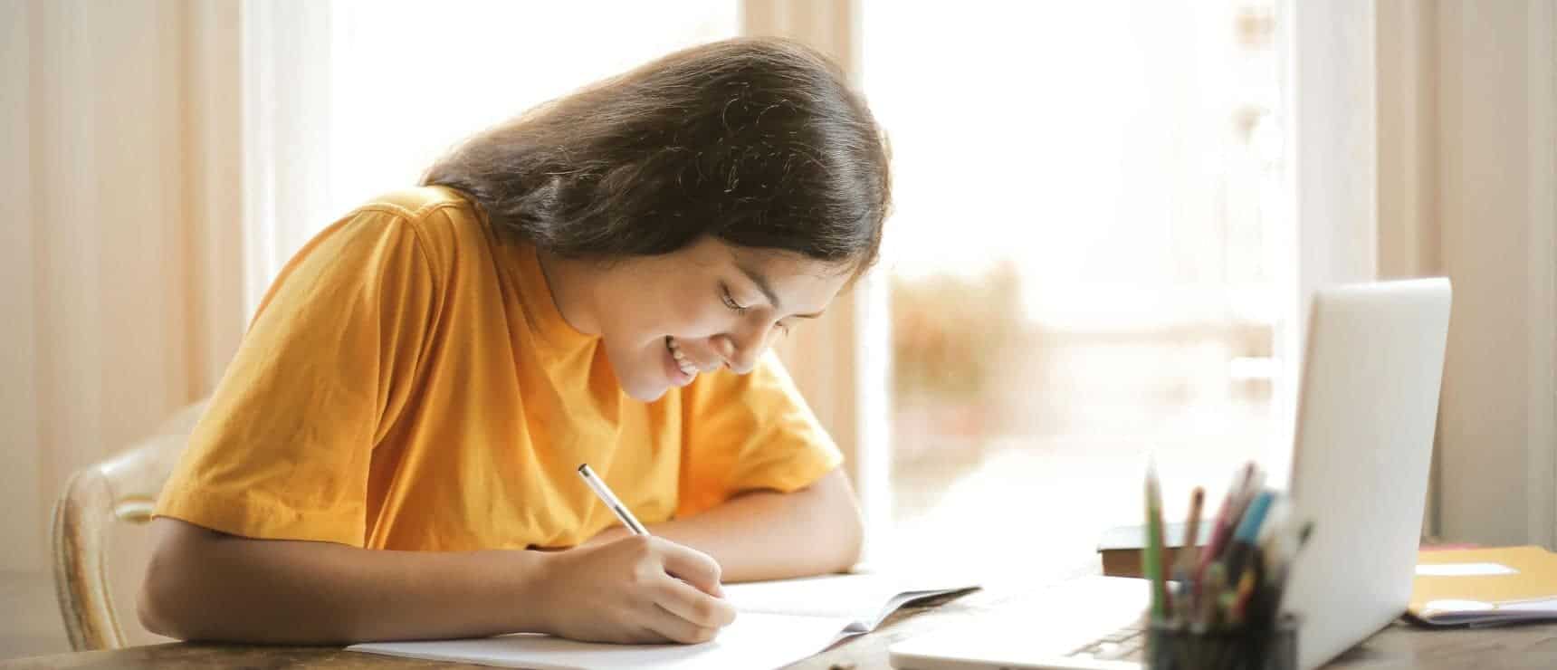 Young girl studying at home with laptop, education, online learning, student, focus, bright, cheerful, digital classroom.