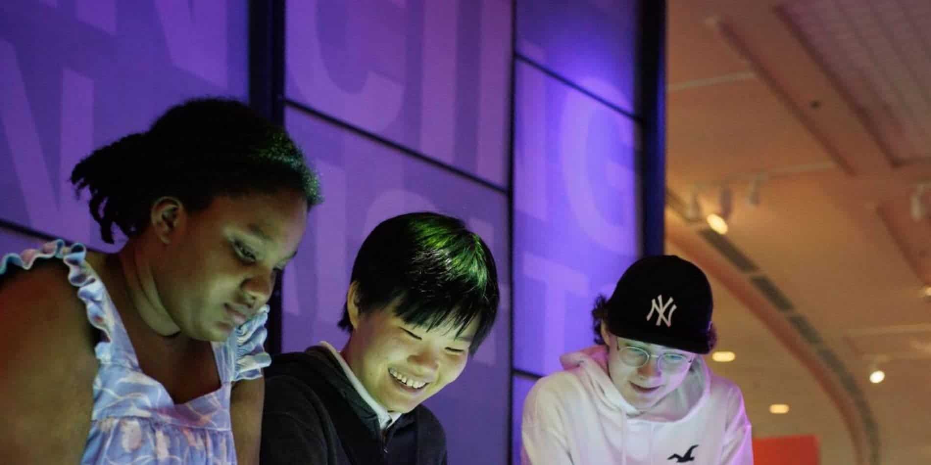 Diverse group of students entertaining and engaging at a school event in a spacious, modern auditorium with vibrant lighting.