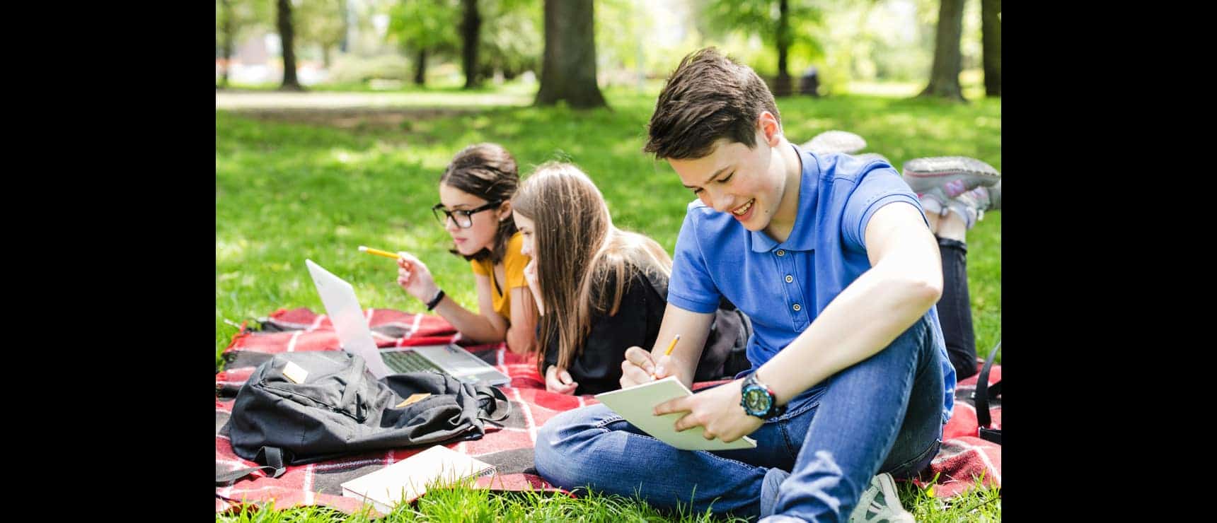Students studying outdoors at a park for World Schools education, promoting academic excellence.