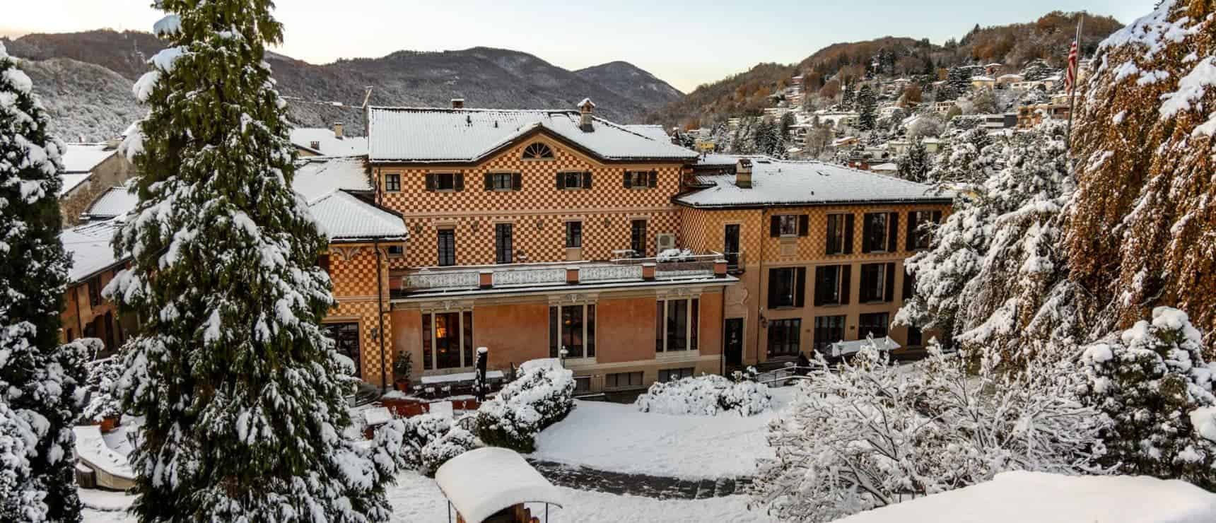 Snow-covered luxury school building in a scenic mountainous area during winter.