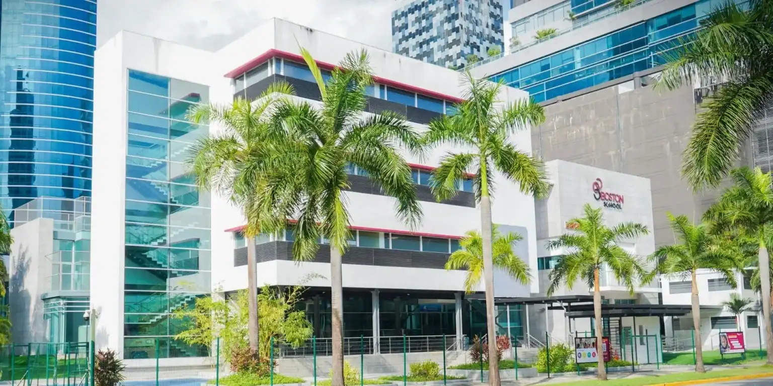 Modern educational facility with lush palm trees in an urban setting.