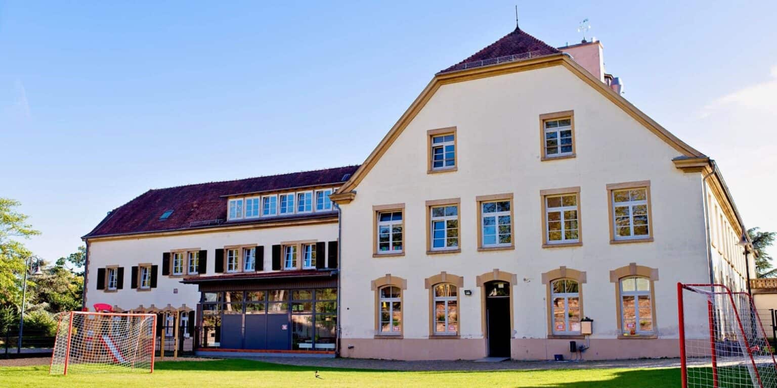 Historical school building with modern amenities on lush green campus for international students.
